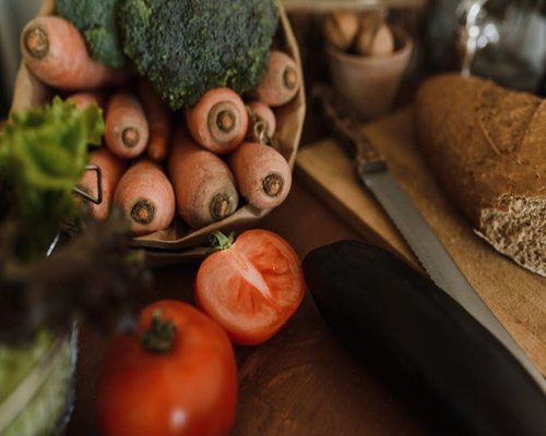 A variety of fresh vegetables and whole grains arranged beautifully on a rustic wooden table