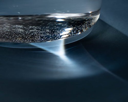 A simple ceramic glass filled with clean sparkling water on a clean surface